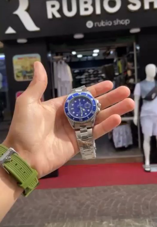 Montre cadran bleu tenue devant la boutique